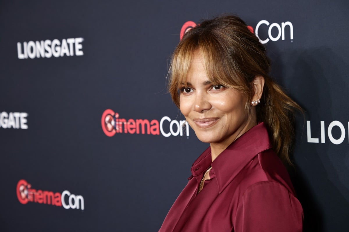 Halle Berry posing at Lionsgate's CinemaCon Presentation and Reception at Caesars Palace in a purple outfit.