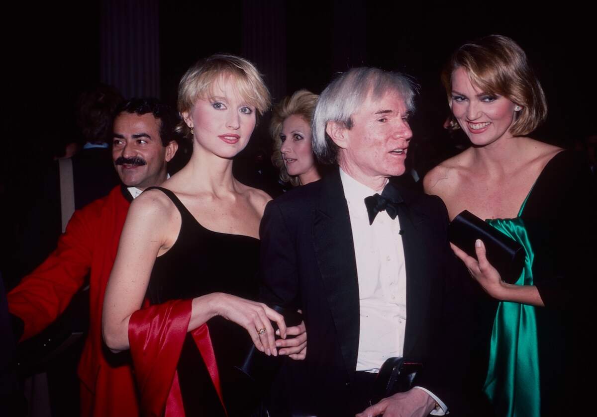 Wearing a classic tuxedo, Andy Warhol stands with friends at the 1982 Met Gala