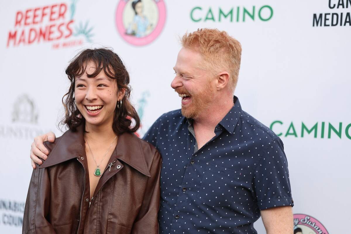 Modern Family stars Aubrey Anderson-Emmons and Jesse Tyler Ferguson laugh together on a red carpet