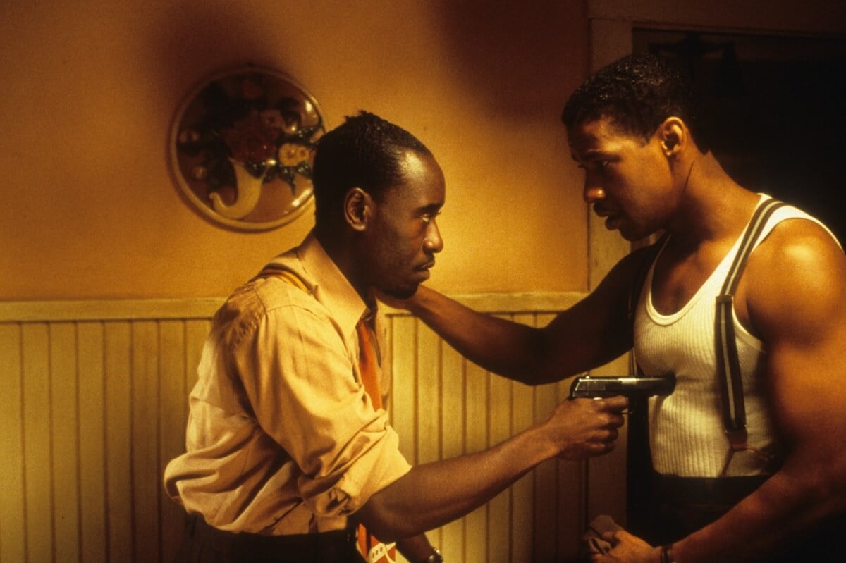 A scene from 'Devil in a Blue Dress' where Don Cheadle is pointing a gun at Denzel Washington.