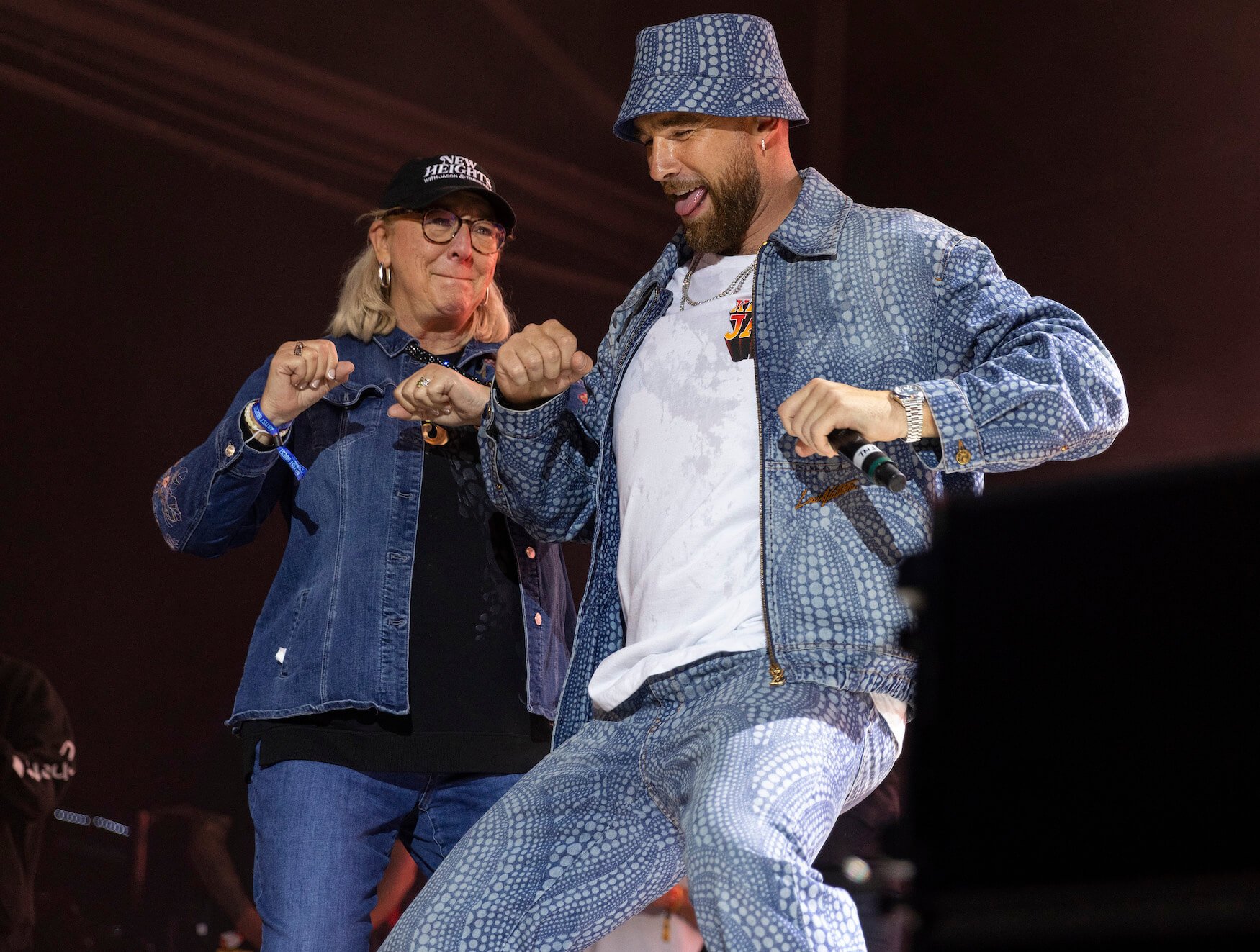 Donna Kelce wearing denim and dancing next to Travis Kelce, who's also wearing denim, at Kelce Jam in 2023