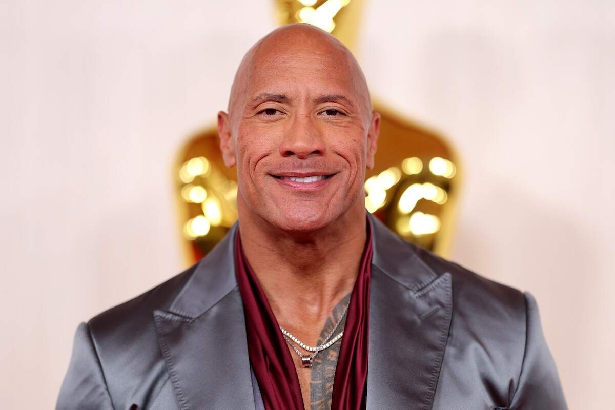 Actor Dwayne Johnson wears a silver suit and red button-up at the Oscars