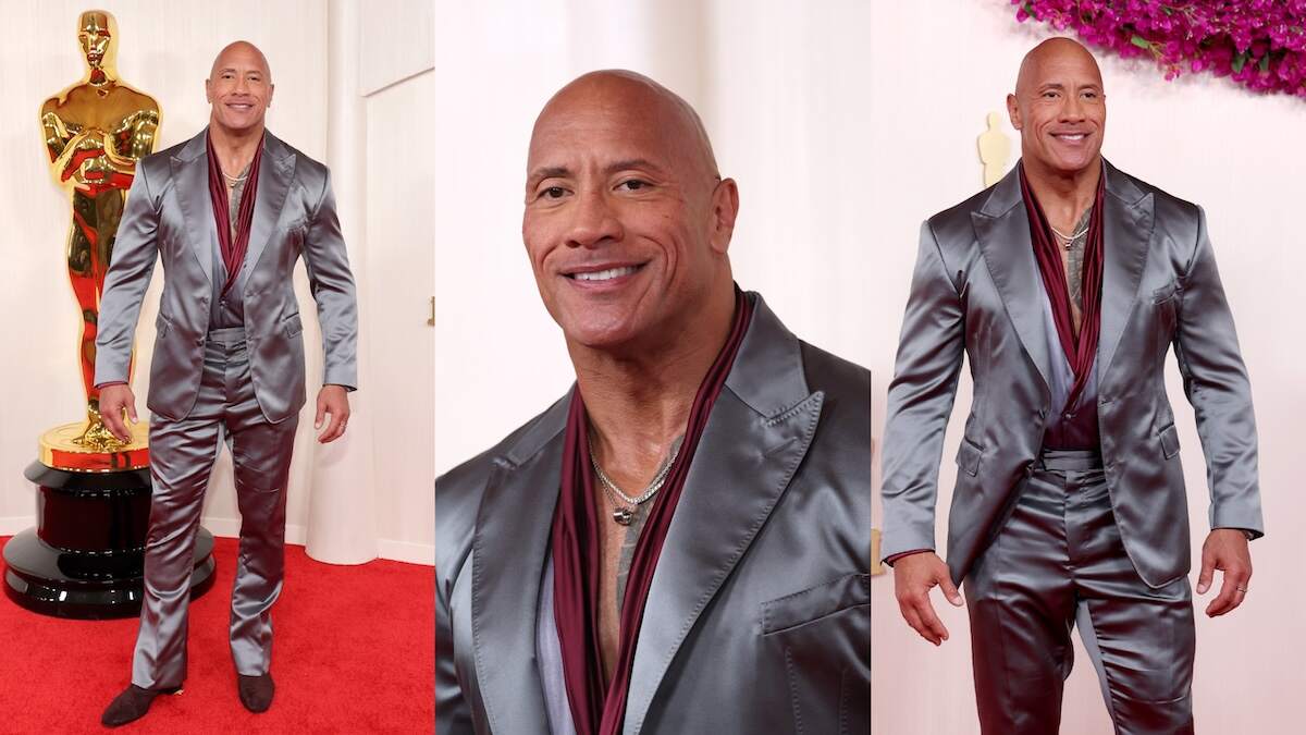 Wearing a silver-gray suit, Dwayne Johnson walks the red carpet at the Academy Awards