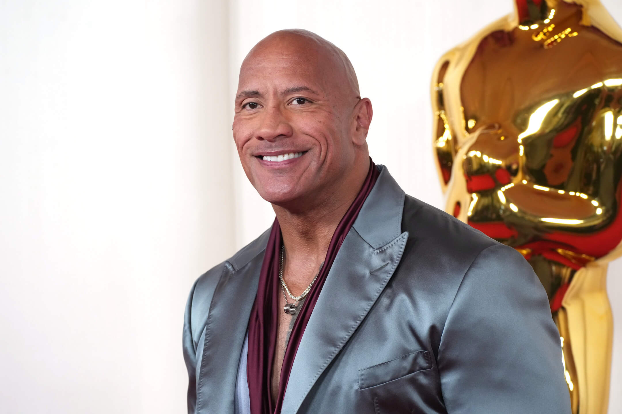 Dwayne 'The Rock' Johnson wearing a metallic blue suit at the Academy Awards in 2024