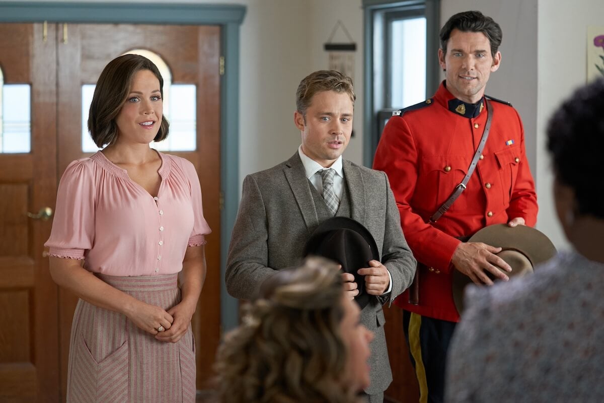 Elizabeth, Tom, and Nathan speak to a group of people in the school in a scene from 'When Calls the Heart'