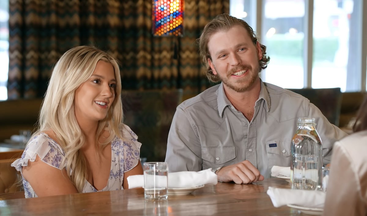 Taylor and Nathan sitting at a table in 'Farmer Wants a Wife' Season 2