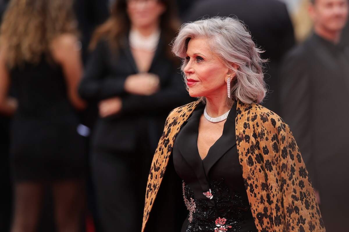 Actor Jane Fonda wears a leopard print jacket, black suit, and diamonds as she walks the red carpet at Cannes Film Festival 2024