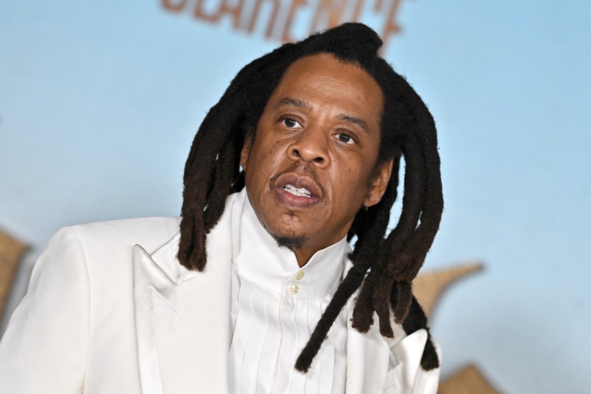 Jay-Z posing in a white suit.