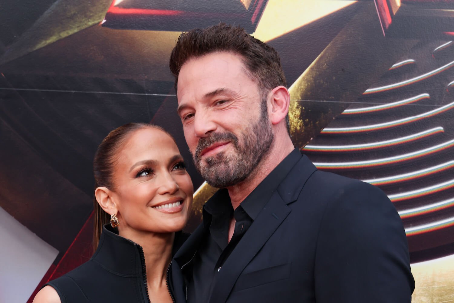 Jennifer Lopez looking up at Ben Affleck as they pose and smile for a film premiere in 2023