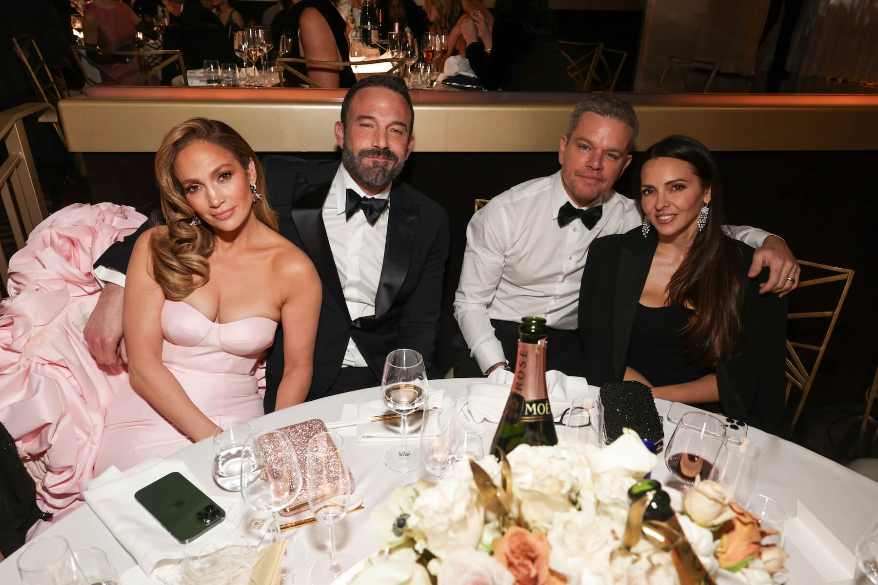 Jennifer Lopez, Ben Affleck, Matt Damon, and Luciana Barroso sitting around a table at the 81st Golden Globes