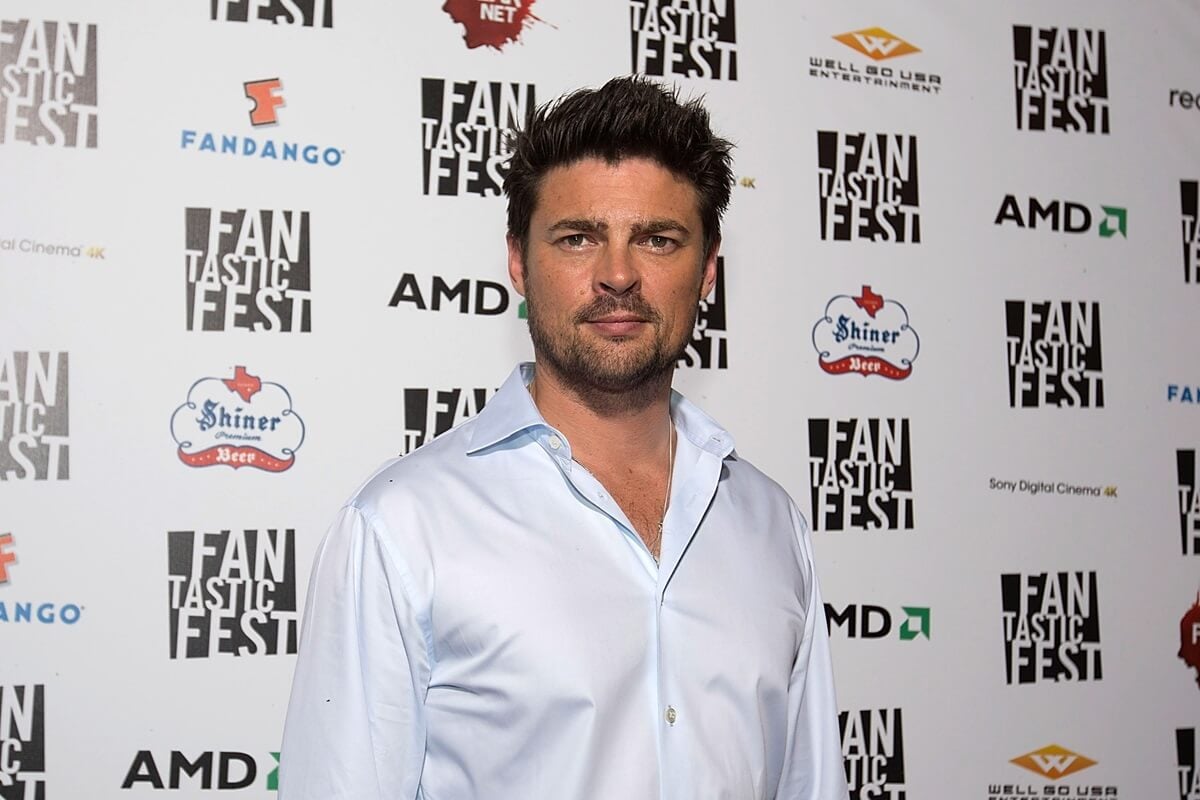 Karl Urban posing a white shirt at the premiere of 'Judge Dredd'.