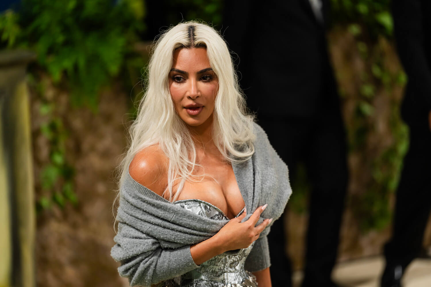 Kim Kardashian wearing a silver dress and a gray cardigan at the 2024 Met Gala