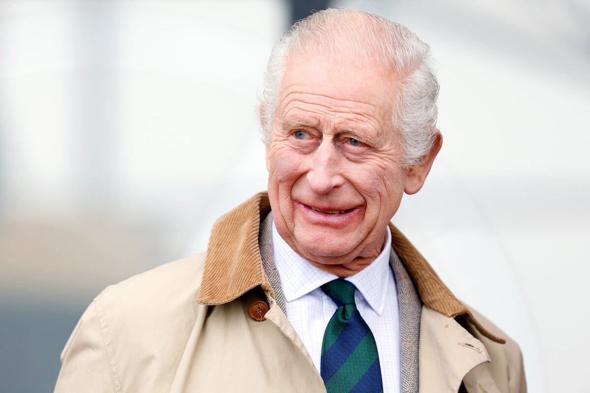 King Charles III, who wanted to buy Prince Archie a playhouse for his birthday, in May 2024 looking on wearing a brown coat.