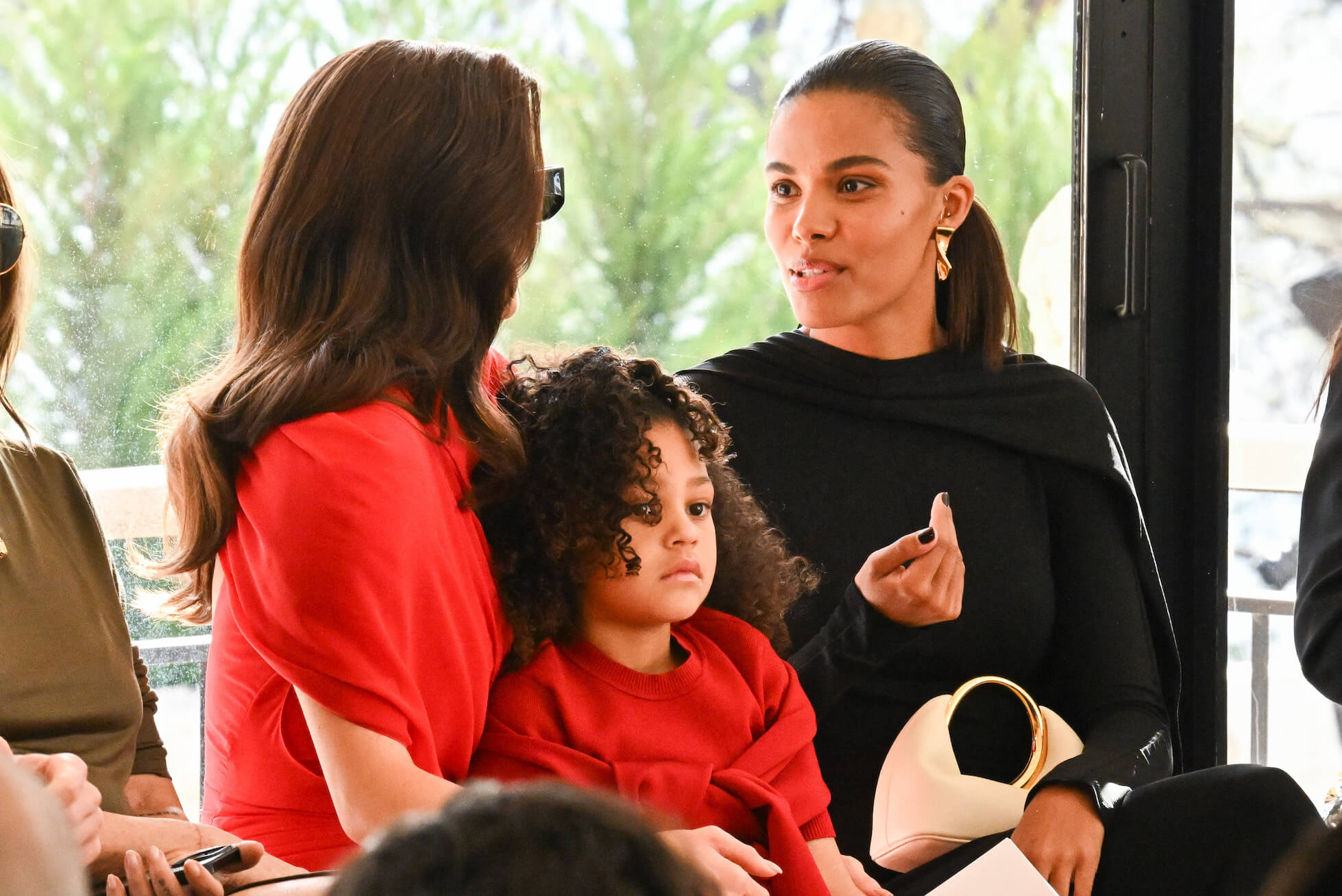 Kylie Jenner speaking to Tina Kunakey with Stormi Webster on her lap