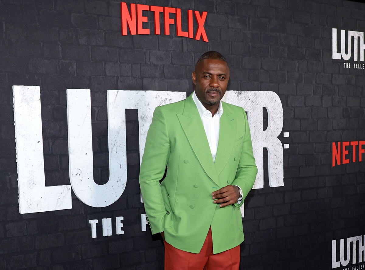 Idris Elba posing in a green outfit at the premiere of 'Luther'.
