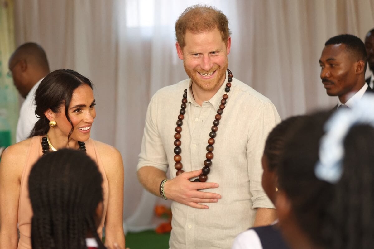 Meghan Markle and Prince Harry speak with students at the Lightway Academy in Abuja, Nigeria