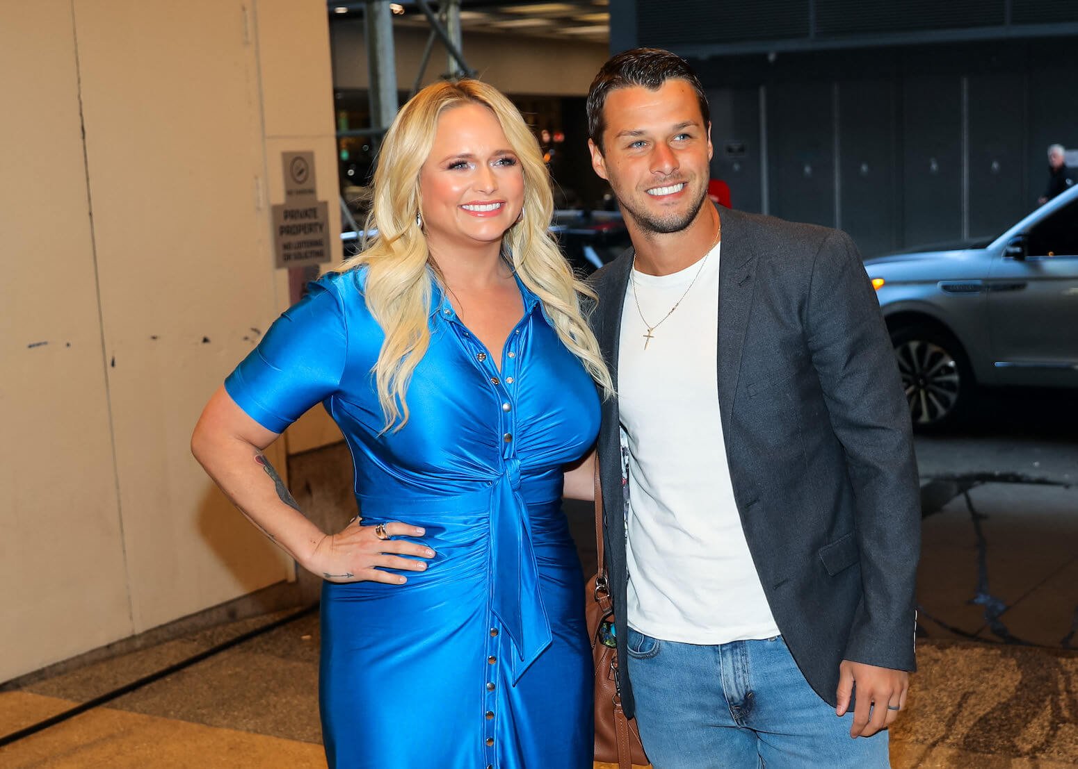 Miranda Lambert in a blue dress posing with her husband, Brendan McLoughlin