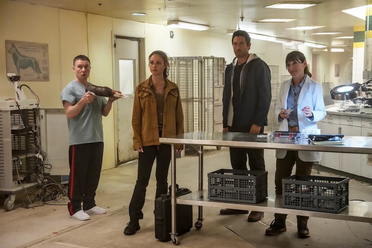 Four people standing behind a table in a room in 'NCIS: Hawai'i' Season 3 finale