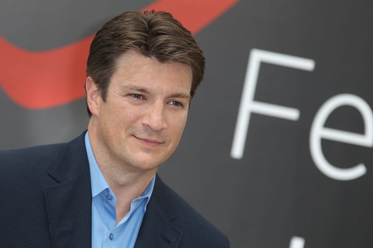 Nathan Fillion posing in a suit at a 'Castle' photocall.