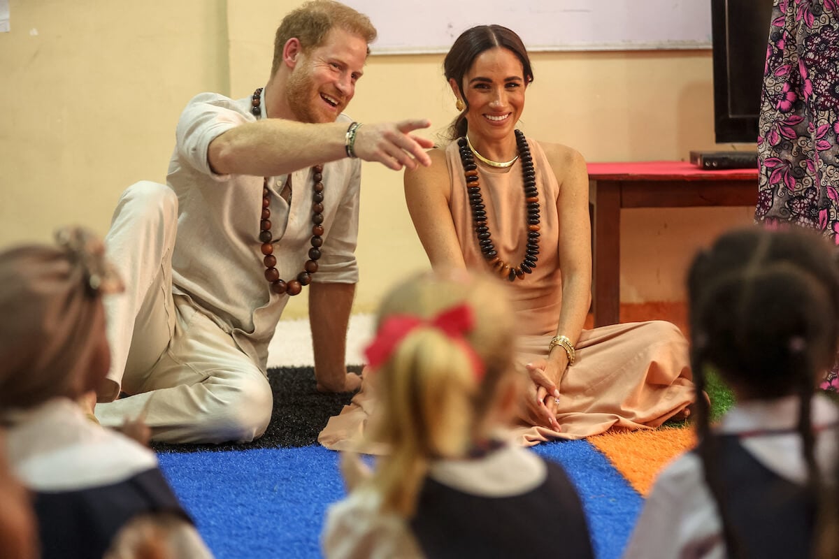 Prince Harry and Meghan Markle, whose Nigeria trip Prince William and King Charles III likely want 'made clear' wasn't official, sit on the floor in Nigeria