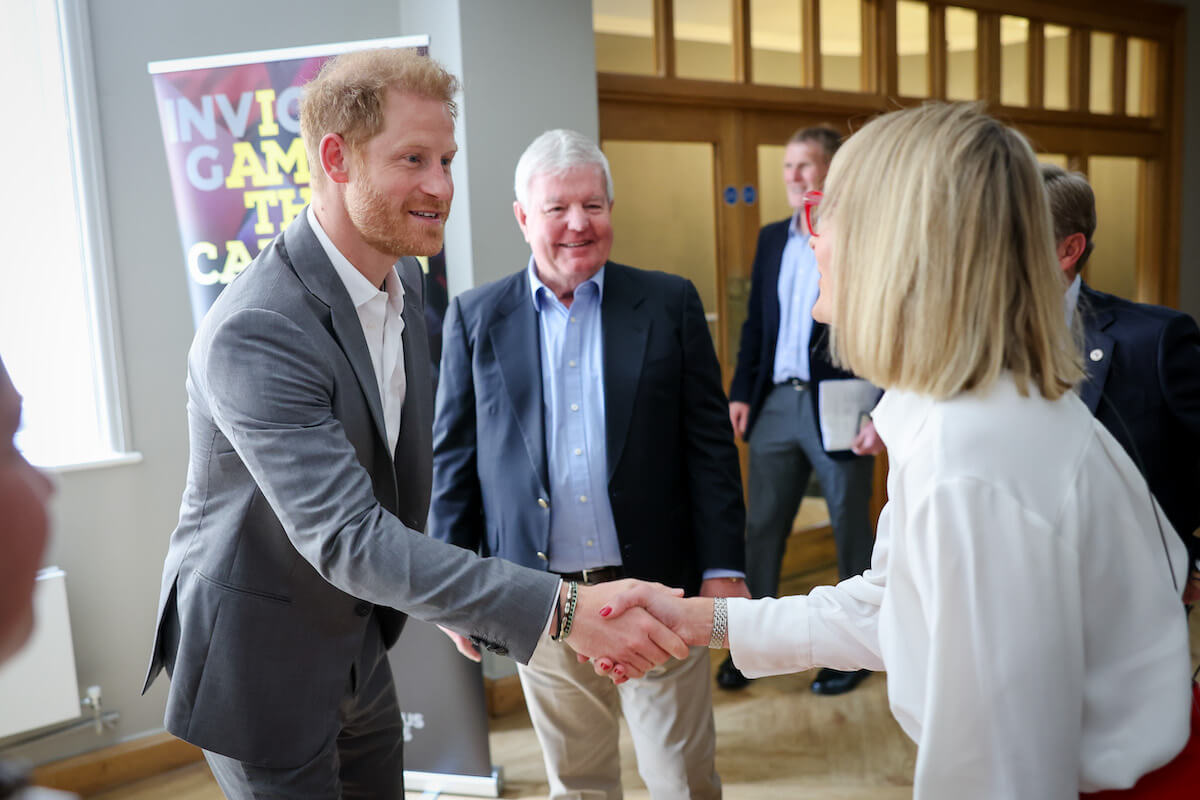 Prince Harry, whose Invictus Games anniversary service won't include any senior British royals, in London, England, shaking hands with Louise Minchin. 