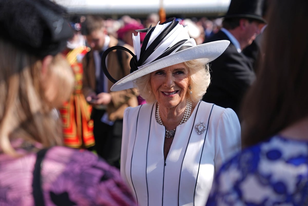 Queen Camilla (formerly Camilla Parker Bowles) speaks to guests attending a Royal Garden Party at Buckingham Palace