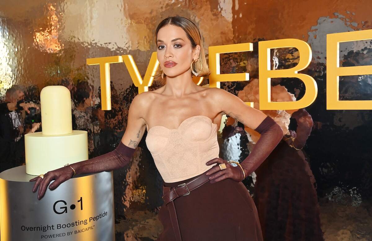 Singer Rita Ora leans against a giant TYPEBEA bottle at the launch party