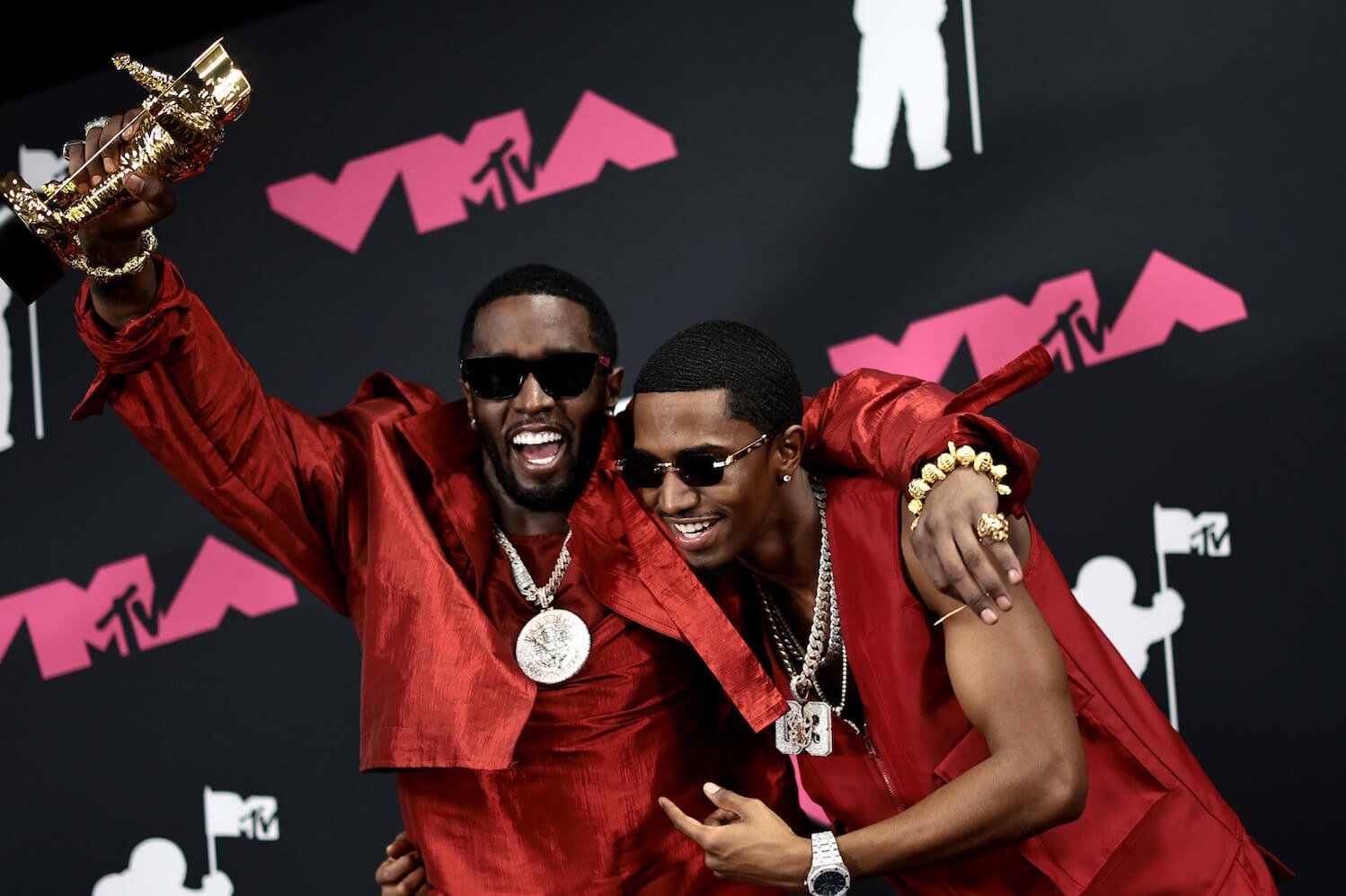 Sean 'P. Diddy' Combs holding up an award at the MTV VMAs while hugging his son, Christian 'King' Combs. They both look elated.