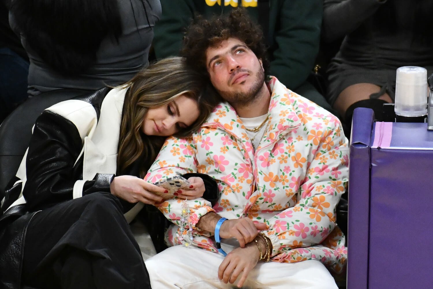 Selena Gomez leaning on Benny Blanco as they sit at a basketball game in 2024