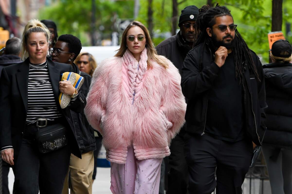 Actor/singer Suki Waterhouse wears a fluffy pink coat and walks down a street in NYC