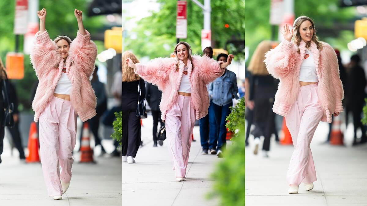 Actor/singer Suki Waterhouse waves to fans as she walks down an NYC street wearing a pink coat and pink pants