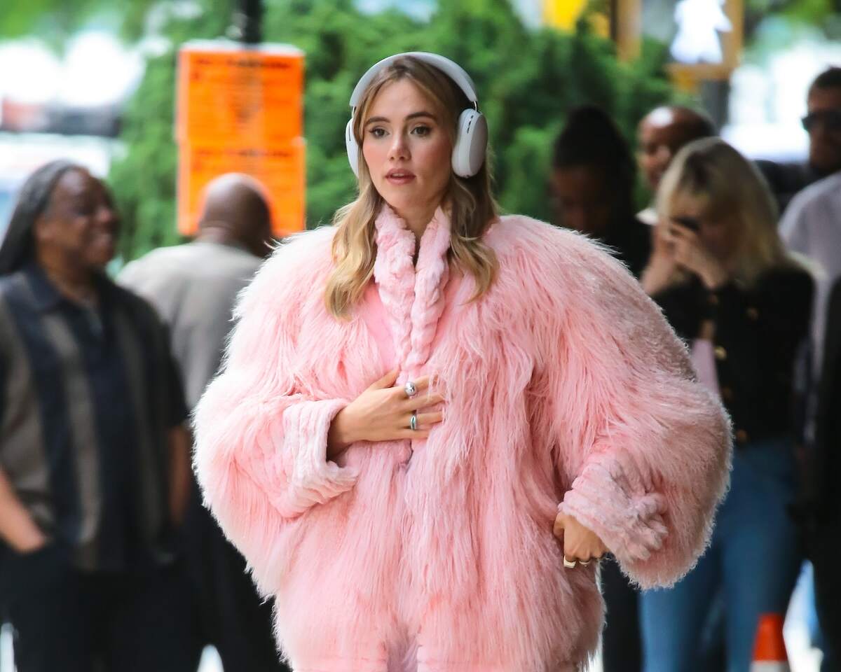 Actor/singer Suki Waterhouse wears a fluffy pink coat and walks down a street in NYC