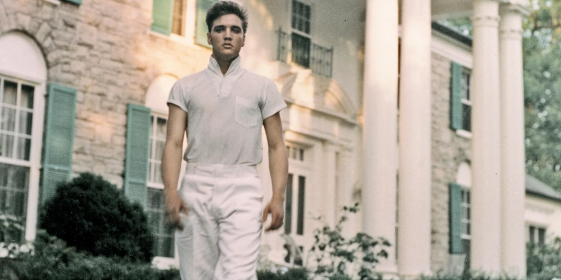 Elvis Presley poses outside of Graceland in Memphis, Tennessee