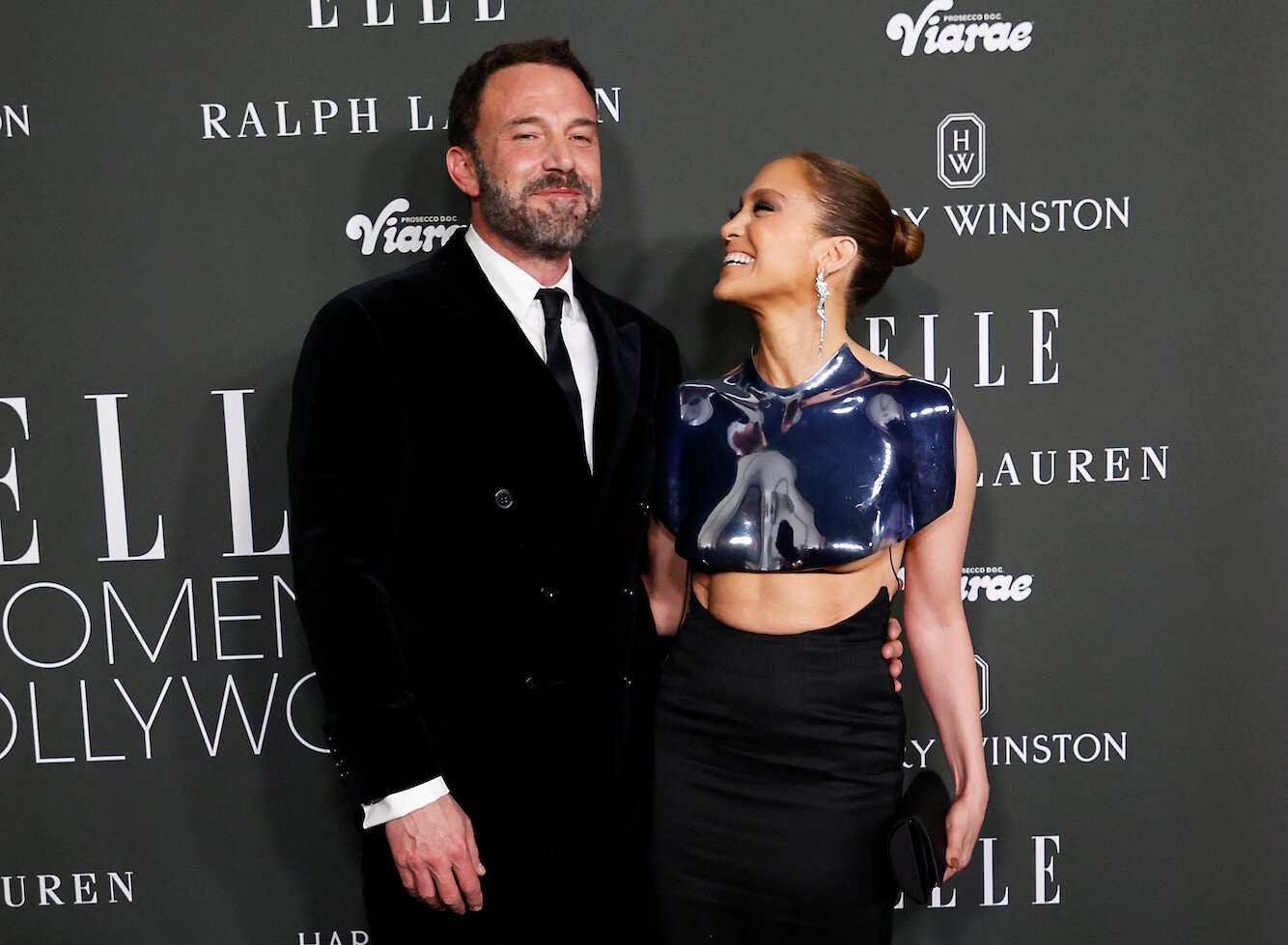 Ben Affleck and Jennifer Lopez smiling at an event with Elle in 2023