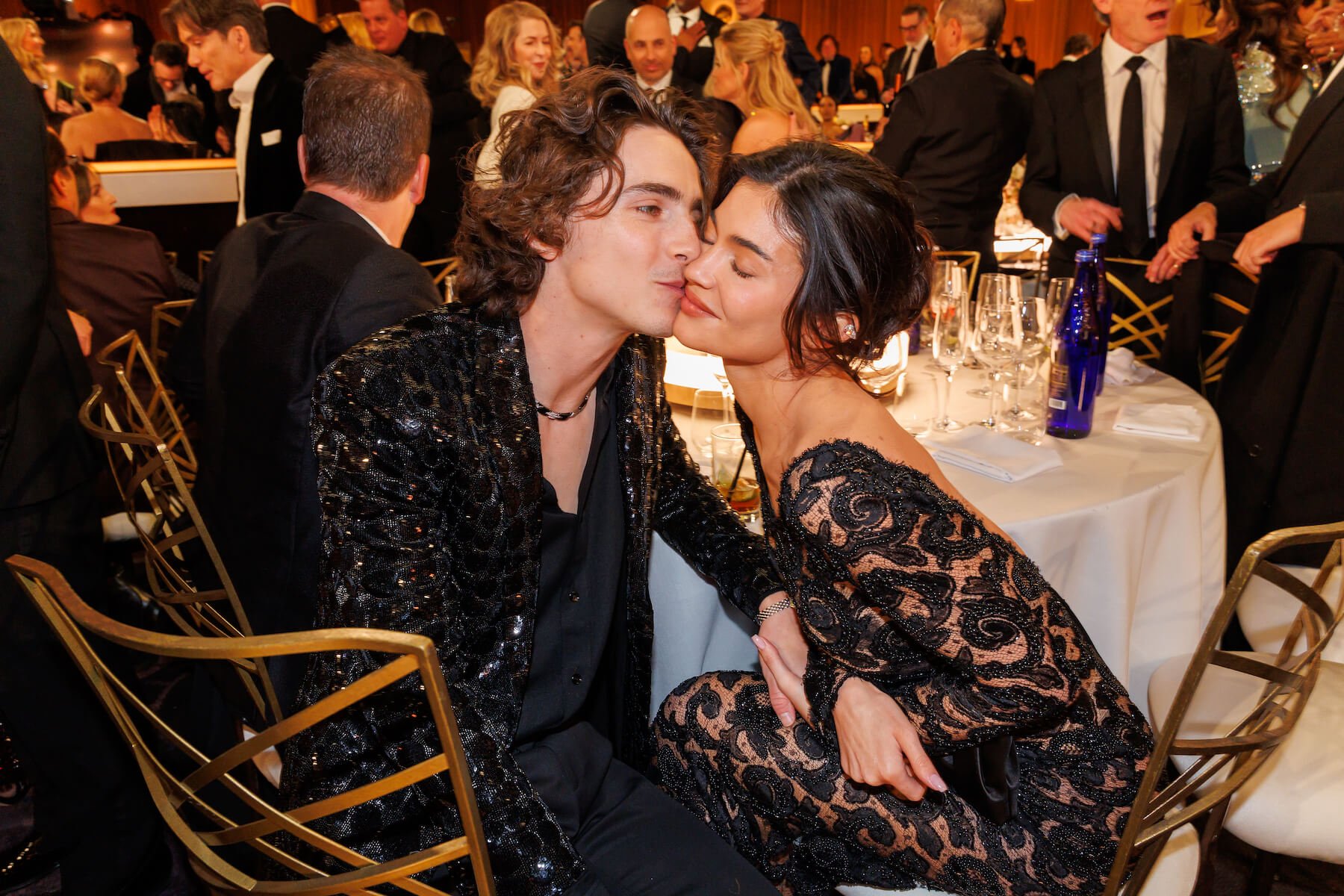 Timothée Chalamet kissing Kylie Jenner's cheek while sitting at the 81st Golden Globe Awards