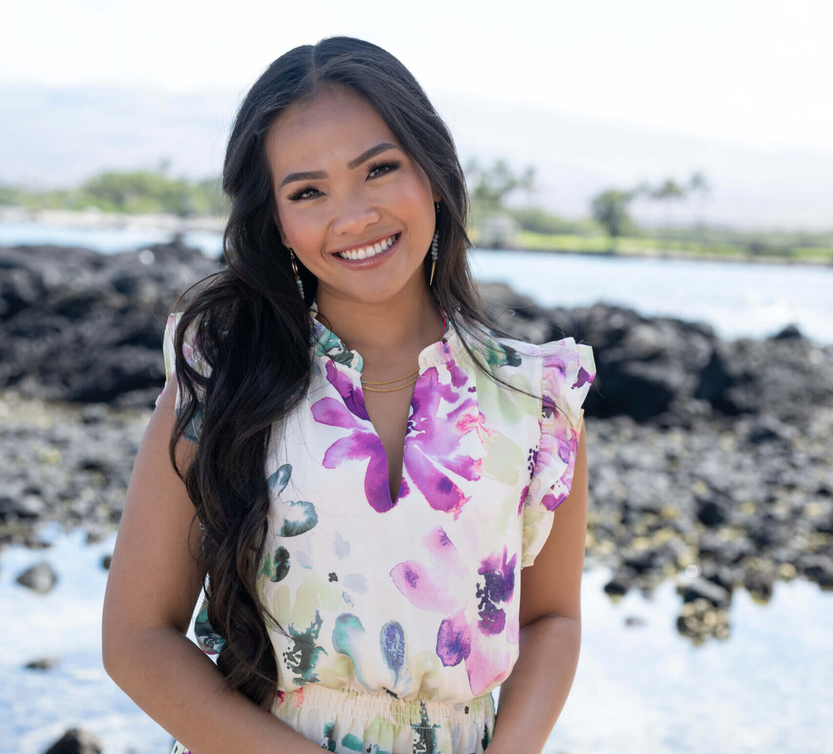 Jenn Tran smiling while looking at the camera. 'The Bachelorette' Season 21 star is dressed in florals in Hawaii.