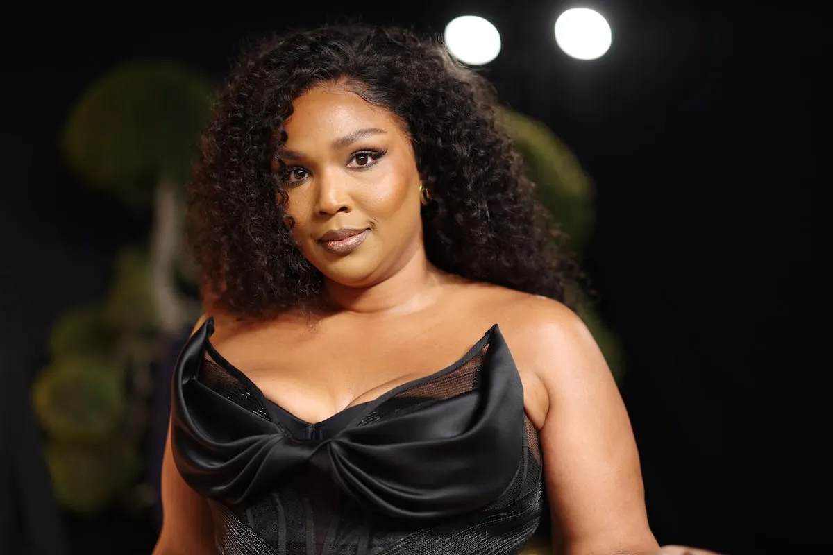 Wearing a black gown, Lizzo smiles for cameras at the 2025 Vanity Fair Oscar Party