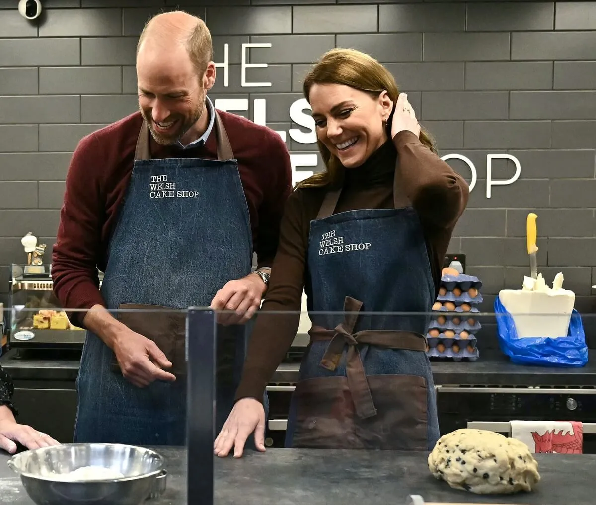 Prince William and Kate Middleton react as they make cakes at The Welsh Cake Shop during a visit to the Pontypridd Market in Wales