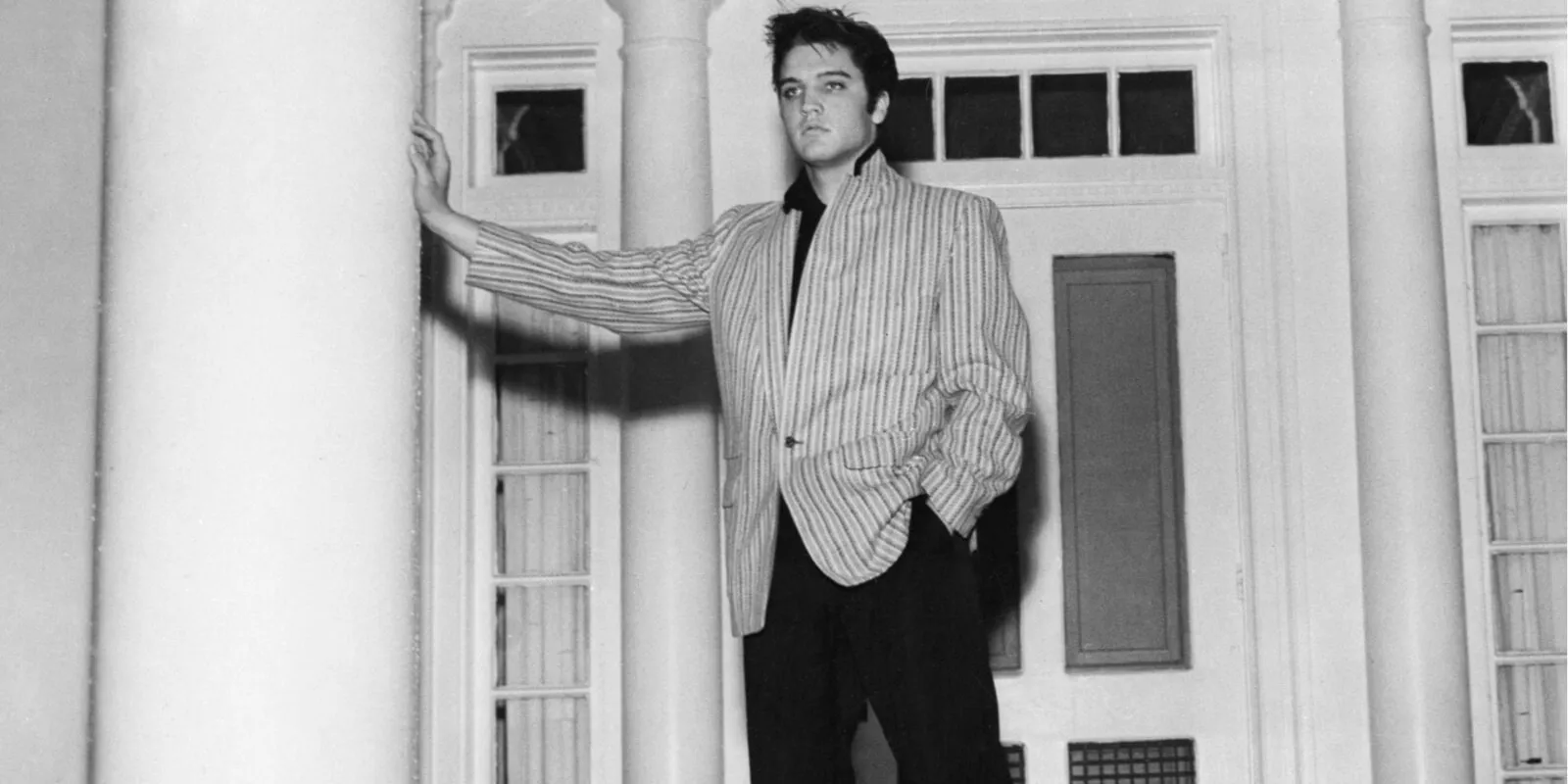 Elvis Presley poses in front of his Graceland home