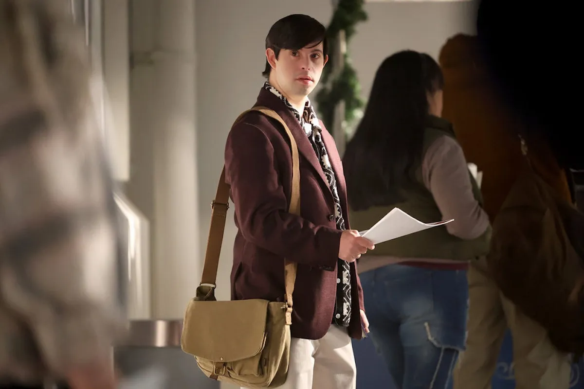Young man in a blazer handing out flyers in NBC's 'Found'