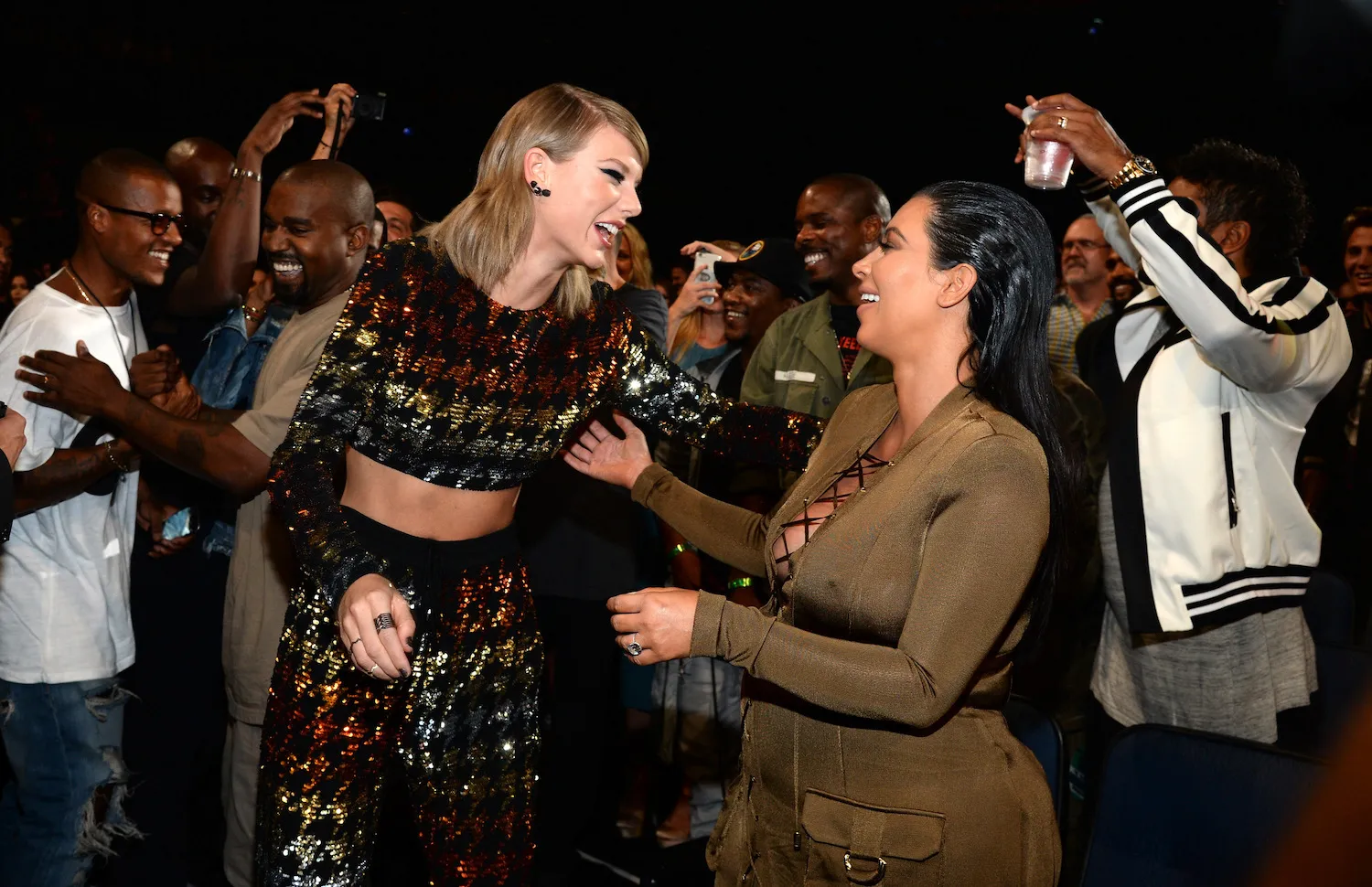 Kim Kardashian and Taylor Swift greeting each other with smiles onstage during the 2015 MTV Video Music Awards