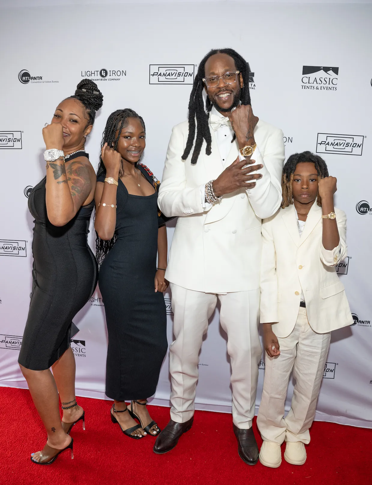 Kesha Epps, Harmony Epps, 2 Chainz, and Halo Epps posing for an event in 2025. 2 Chainz and Halo are wearing white suits, and Kesha and Harmony are wearing black dresses.