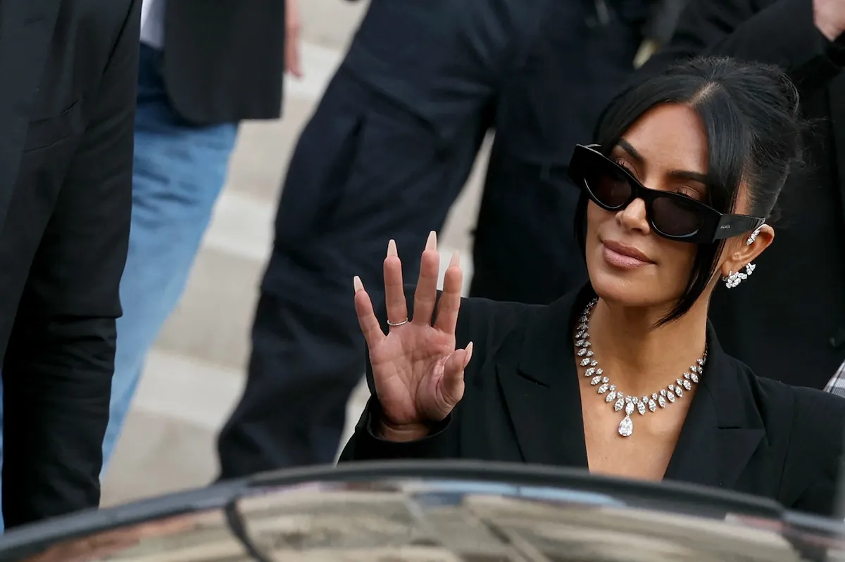 Kim Kardashian, wearing a diamond necklace and sunglasses, outside a Paris court in May 2025
