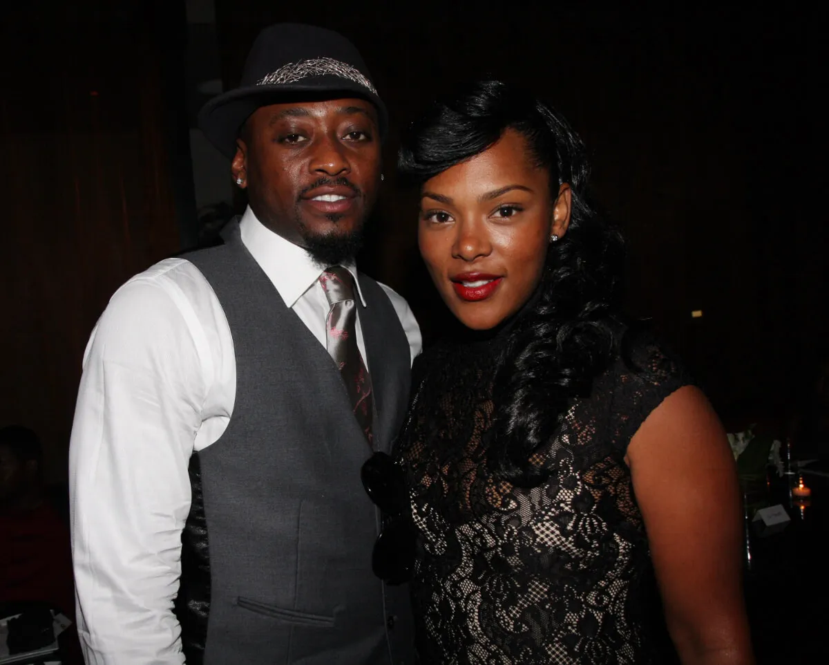 Omar Epps wears a vest and tie and stands with his wife, Keisha Spivey. She wears a black lace shirt.