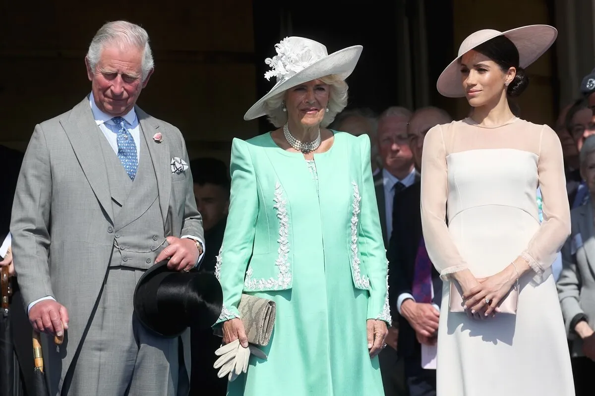 Meghan Markle standing next to Camilla Parker Bowles and then-Prince Charles during his 70th Birthday Patronage Celebration held at Buckingham Palace