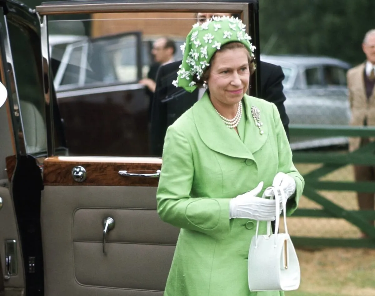 Queen Elizabeth II arriving to polo at Smiths Lawn Windsor after ascot races wearing a green coat dress and hat