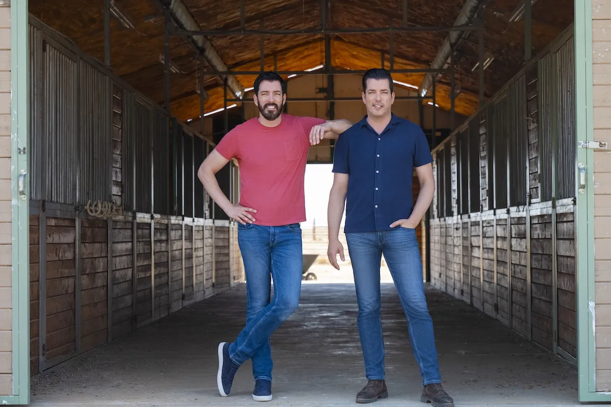 The Property Brothers standing in a barn in a promotional photo for 'Chasing the West'