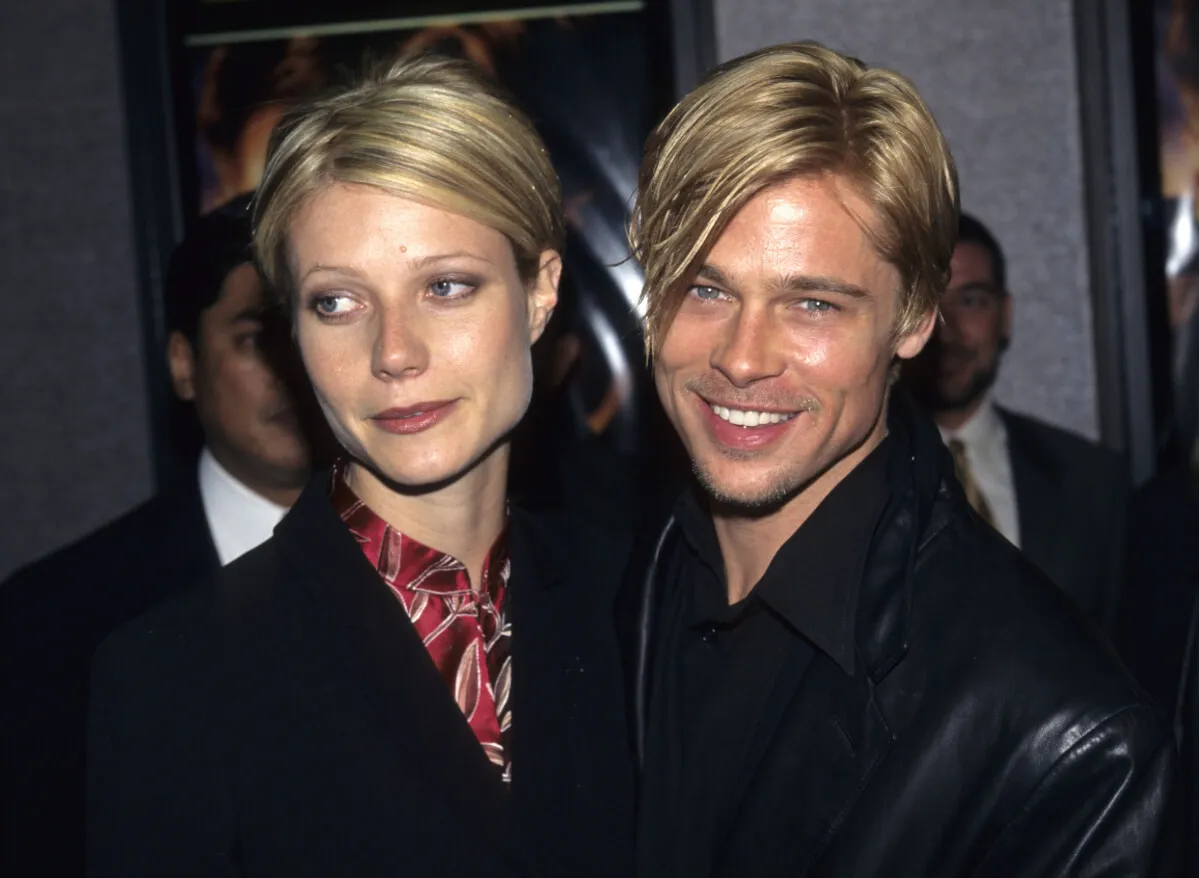 Gwyneth Paltrow and Brad Pitt wear black jackets and stand together.