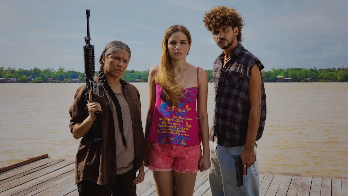 A woman holding a gun standing next to a teen girl and a young man