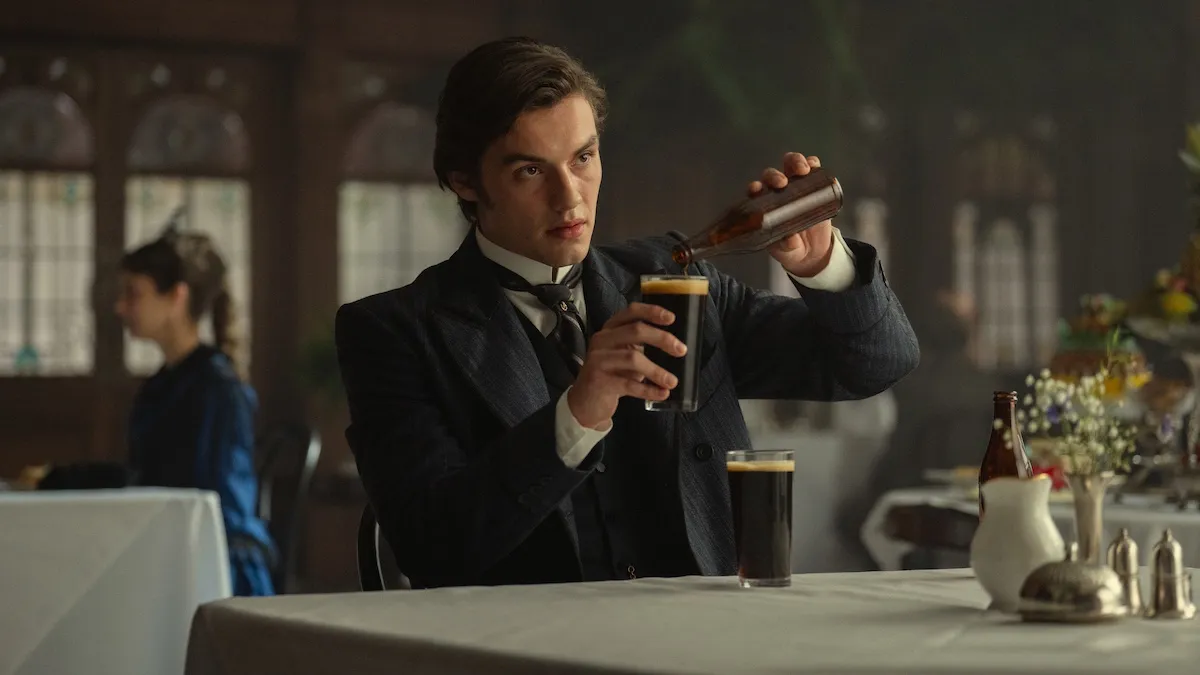 Man in a old-fashioned suit pouring a beer into a glass in Netflix's 'House of Guinness'